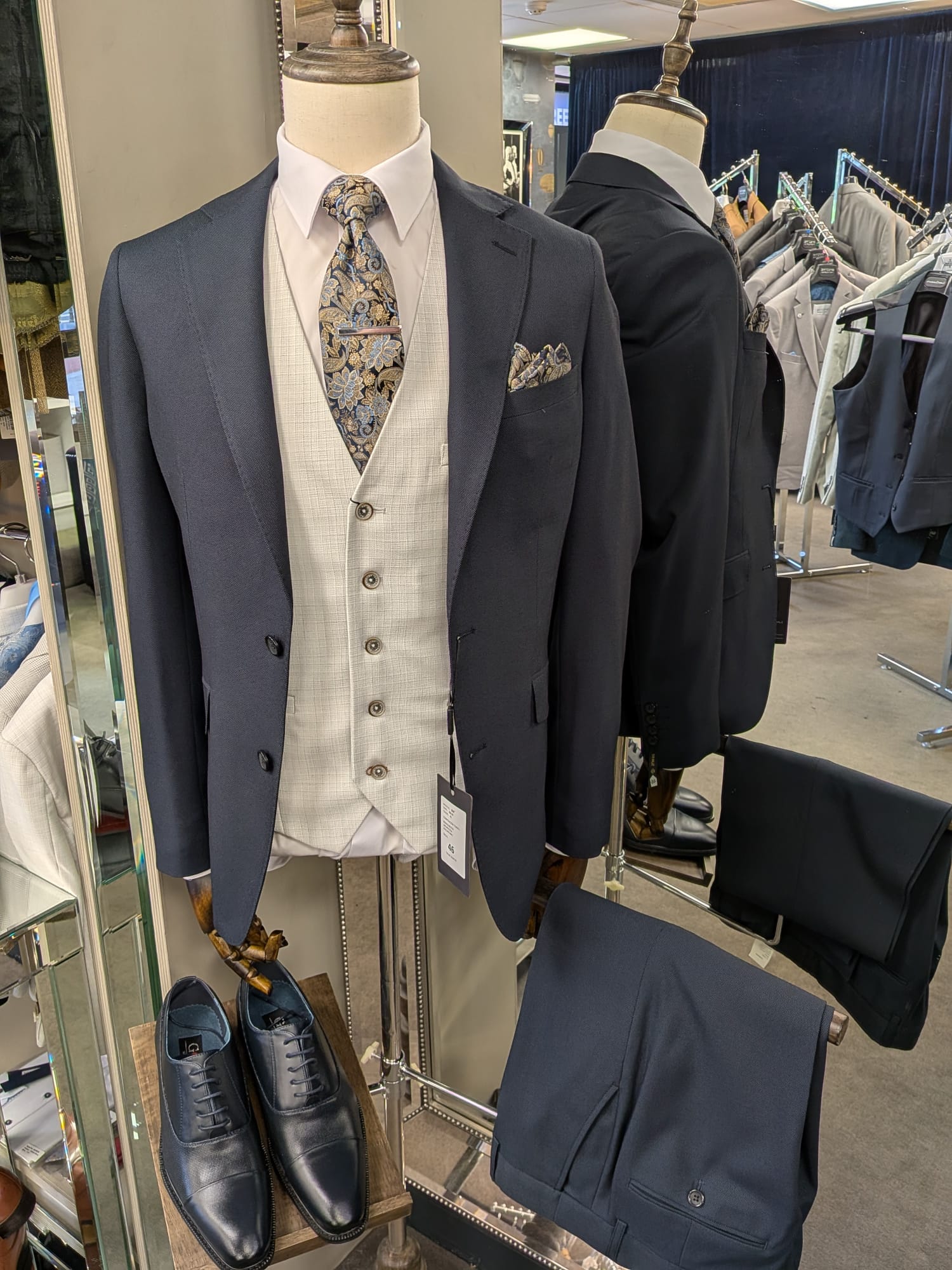 Men's suit on a mannequin with accessories in a store setting