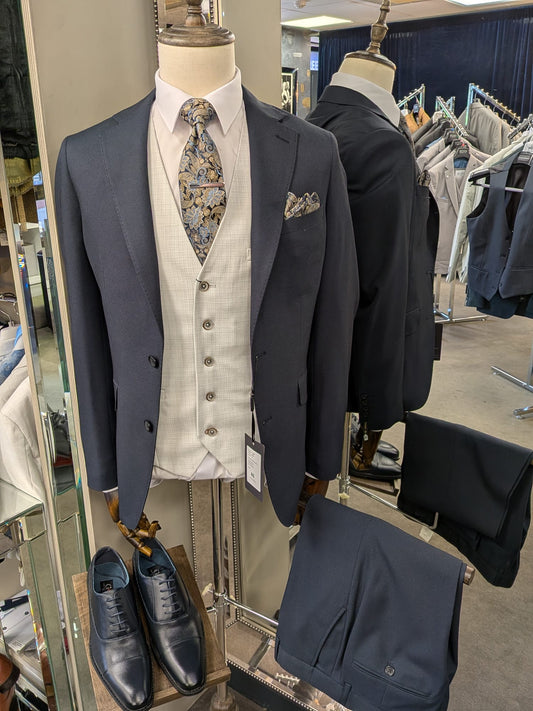 Men's suit on a mannequin with accessories in a store setting