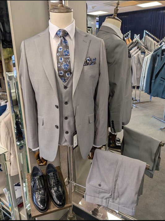 Gray suit on a mannequin in a store setting with other clothing items.