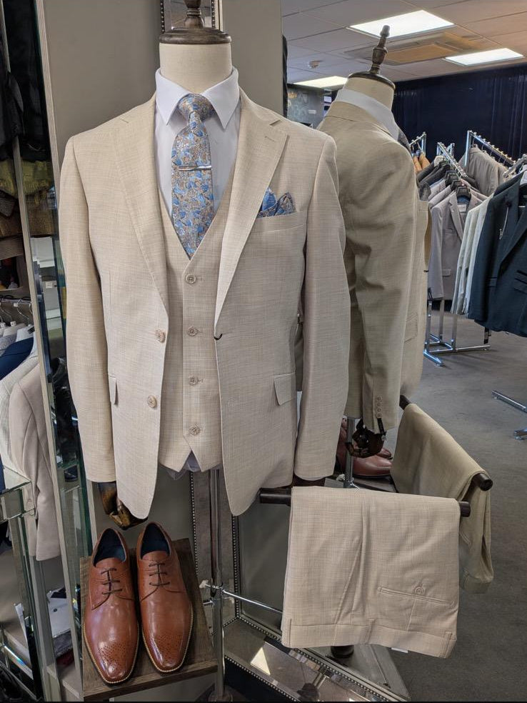 Beige suit on a mannequin with shoes and accessories in a store setting