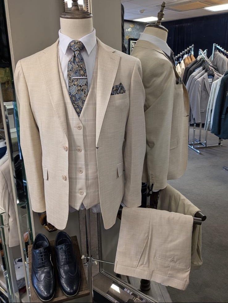 Beige suit on a mannequin with shoes and tie in a store setting