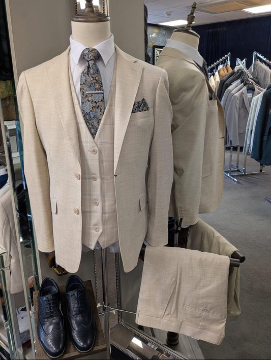 Beige suit on a mannequin with shoes and tie in a store setting