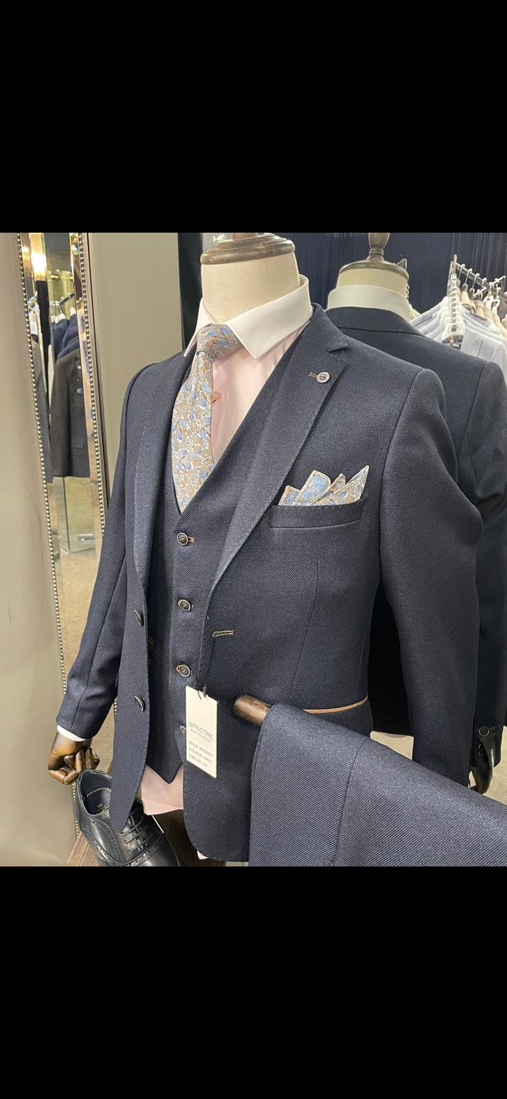 Navy suit on a mannequin with a white shirt and pocket square in a store setting